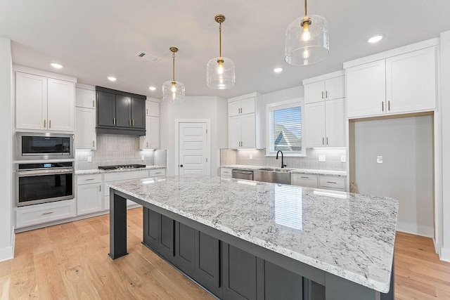 6416 S 59th St, Rogers, AR 72758 - kitchen with stainless steel appliances, white cabinetry, backsplash, and recessed lighting