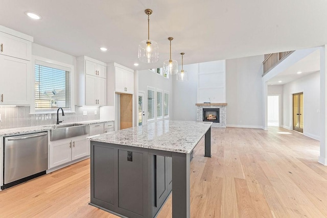 6416 S 59th St, Rogers, AR 72758 - kitchen featuring dishwasher, white cabinets, backsplash, light wood finished floors, and light stone counters