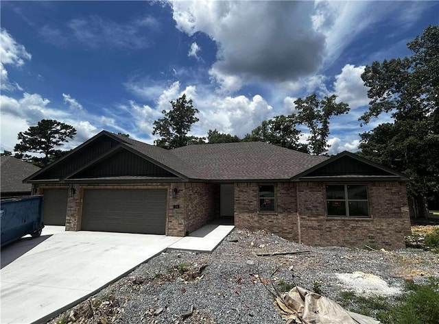 34 Brierfield Ln, Bella Vista, AR 72714 - view of front facade featuring an attached garage, brick siding, driveway, and a shingled roof