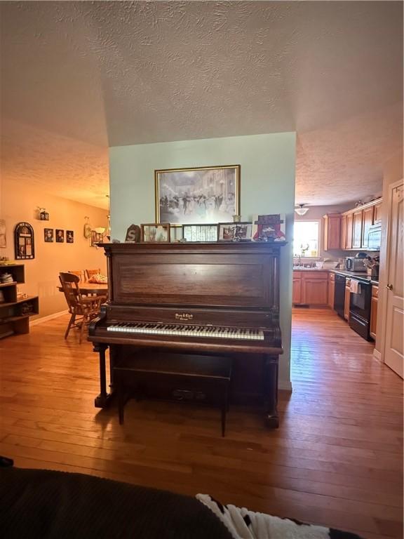 1306 Sunset Blvd, Berryville, AR 72616 - room details featuring wood finished floors, a textured ceiling, and black appliances