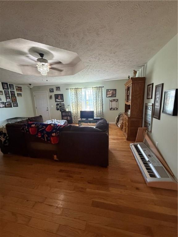 1306 Sunset Blvd, Berryville, AR 72616 - living area with ceiling fan, wood finished floors, a textured ceiling, and a raised ceiling