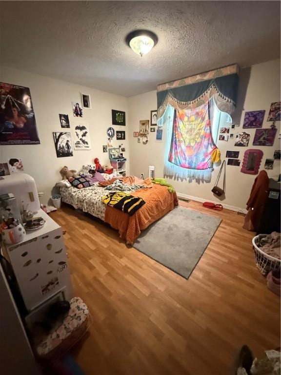 1306 Sunset Blvd, Berryville, AR 72616 - bedroom with wood finished floors and a textured ceiling