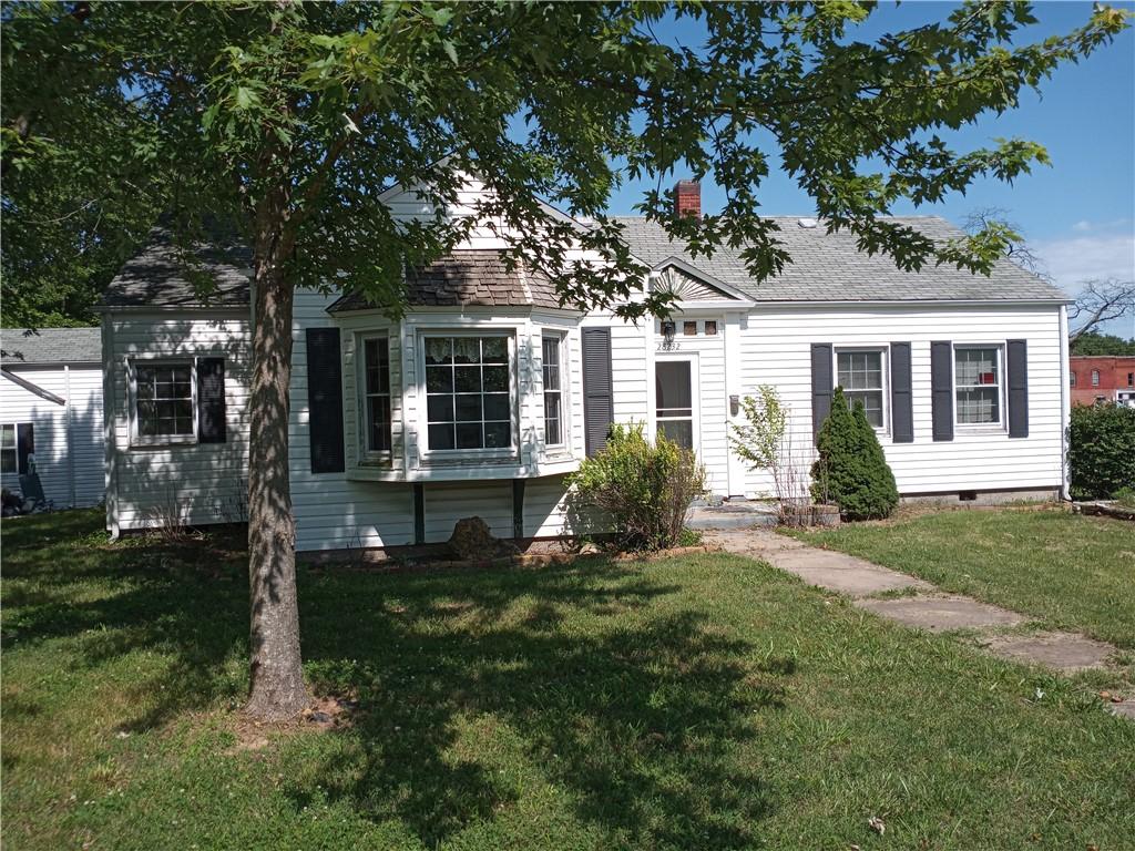 28232 Frisco St, Seligman, MO 65745 - view of front of house featuring a front lawn, a chimney, and roof with shingles