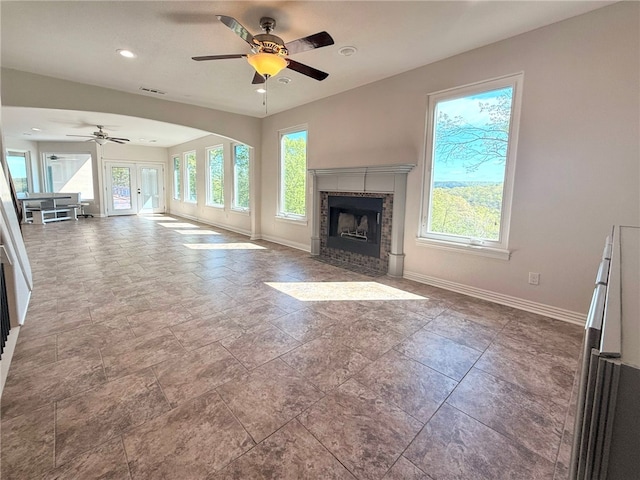 unfurnished living room featuring ceiling fan, visible vents, a fireplace with flush hearth, baseboards, and recessed lighting