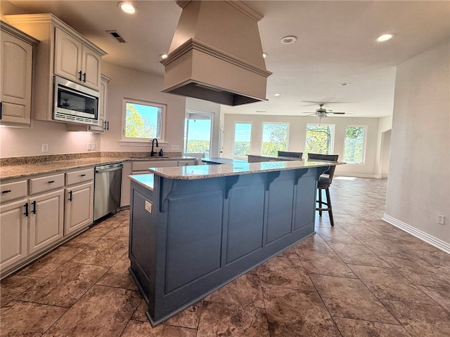 14689 Frisco Springs Rd, Lowell, AR 72745 - kitchen with appliances with stainless steel finishes, a kitchen breakfast bar, a sink, baseboards, and recessed lighting