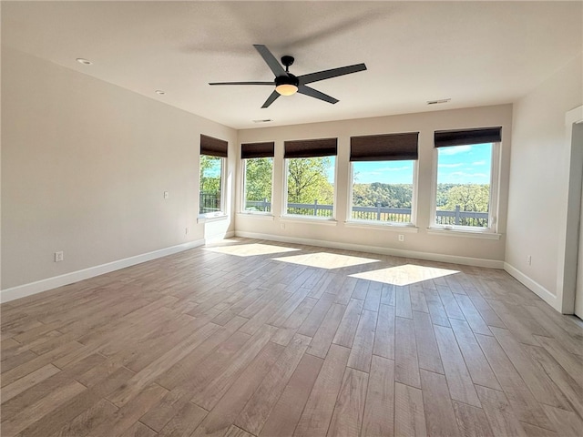 spare room with baseboards, ceiling fan, wood finished floors, and visible vents