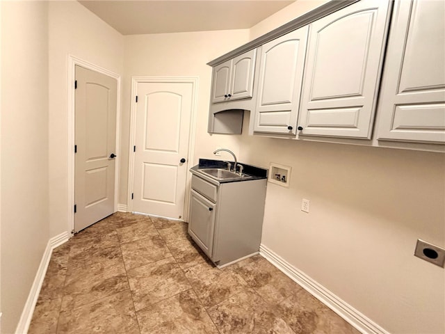 laundry room featuring electric dryer hookup, cabinet space, a sink, baseboards, and hookup for a washing machine