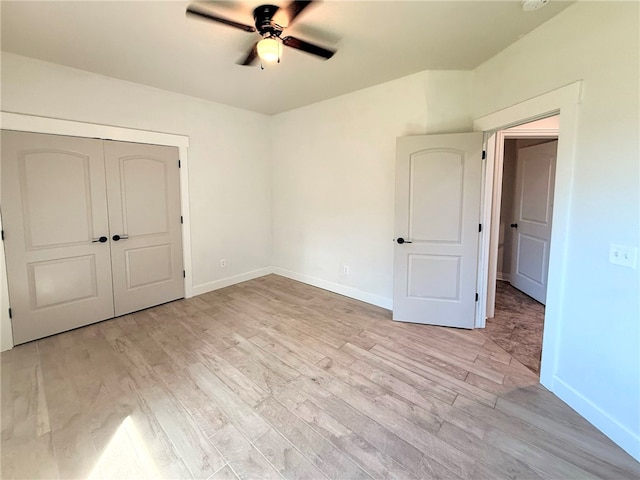 spare room with baseboards, a ceiling fan, and light wood-style flooring