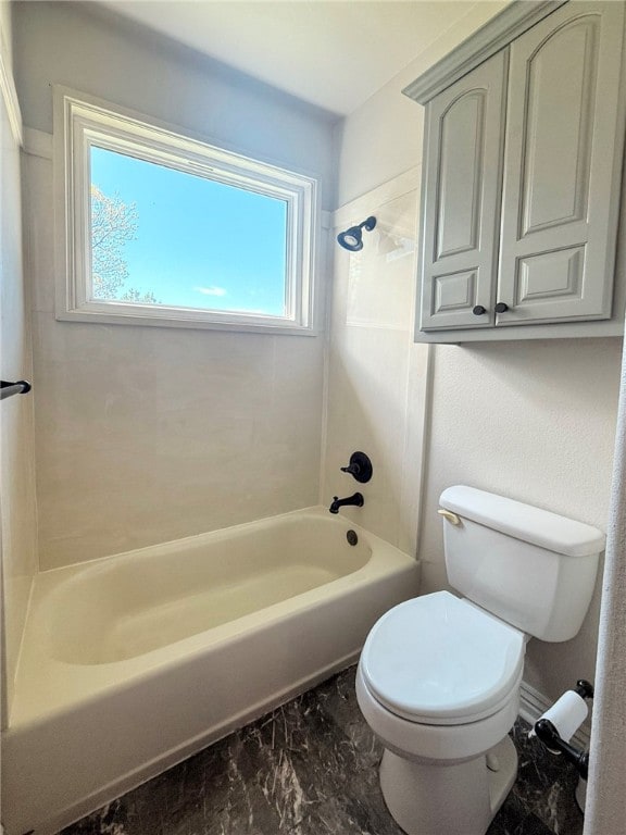 full bath with washtub / shower combination, toilet, and marble finish floor