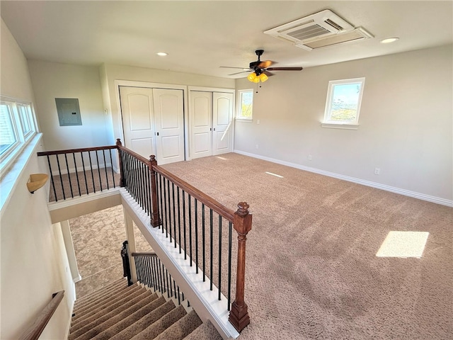 stairs featuring baseboards, ceiling fan, recessed lighting, electric panel, and carpet