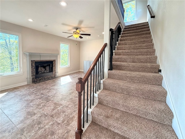 stairs with baseboards, recessed lighting, ceiling fan, and a tiled fireplace