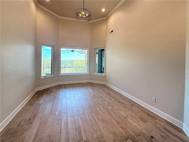 14689 Frisco Springs Rd, Lowell, AR 72745 - spare room with a chandelier, baseboards, crown molding, wood finished floors, and a high ceiling