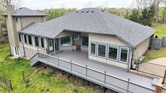 back of house featuring fence, a shingled roof, a yard, and a deck