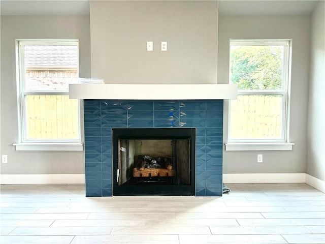 708 W Taylor St, Siloam Springs, AR 72761 - room details featuring a tiled fireplace, baseboards, and wood finished floors