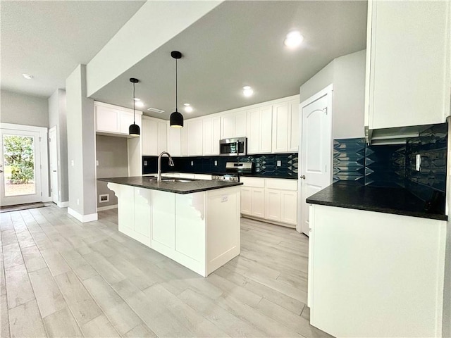 708 W Taylor St, Siloam Springs, AR 72761 - kitchen featuring stainless steel appliances, a sink, backsplash, and dark countertops