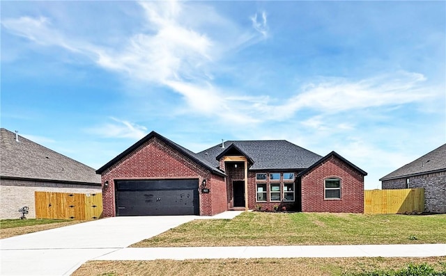 view of front of property with a front lawn, an attached garage, concrete driveway, and fence