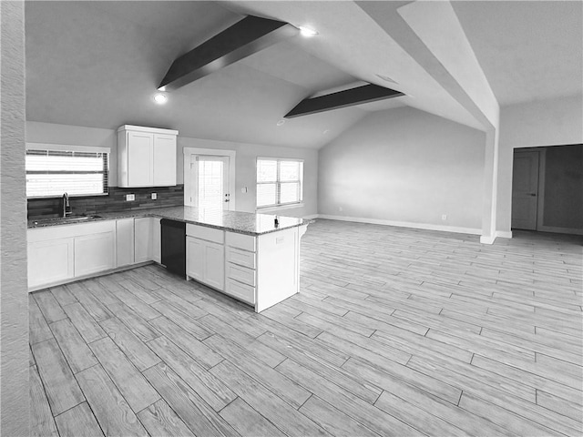 kitchen featuring a sink, open floor plan, dishwasher, stone countertops, and white cabinets