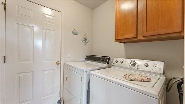 clothes washing area featuring washing machine and clothes dryer and cabinet space