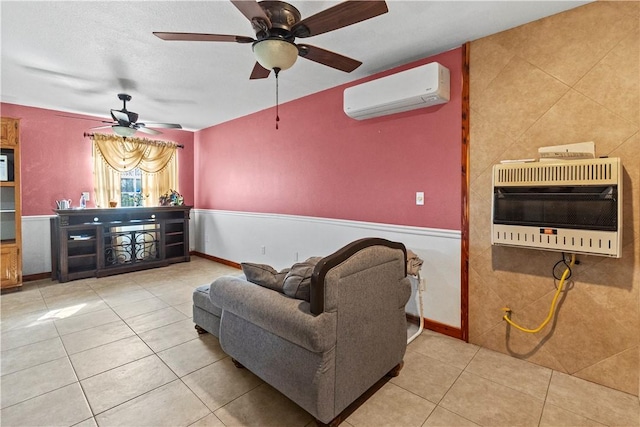 living room with an AC wall unit, heating unit, ceiling fan, baseboards, and tile patterned flooring