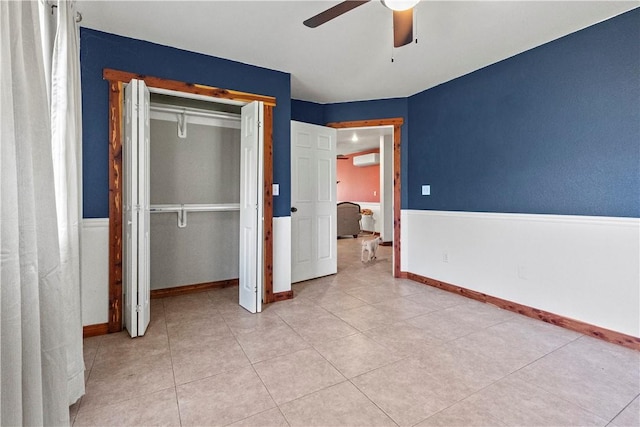 unfurnished bedroom with a wall mounted air conditioner, a closet, a ceiling fan, and baseboards