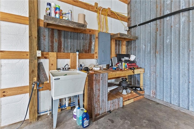 interior space with unfinished concrete floors and electric panel