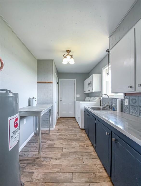 4802 Greenbriar Ln, Everton, AR 72633 - kitchen featuring a sink, washer and clothes dryer, light wood-type flooring, electric water heater, and light countertops