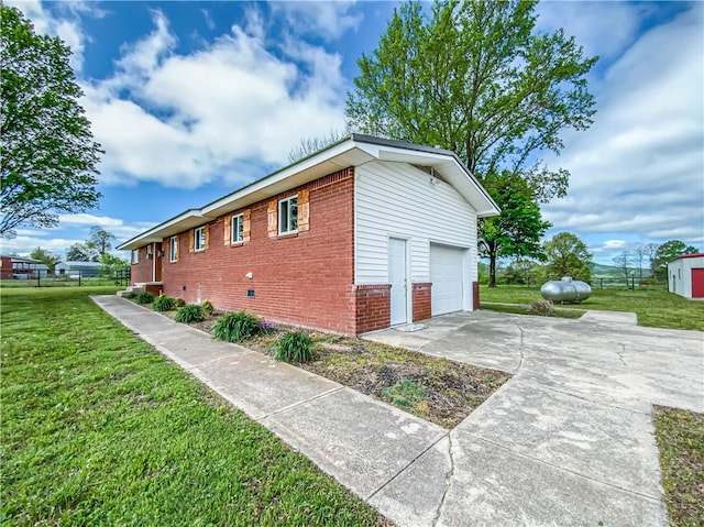 4802 Greenbriar Ln, Everton, AR 72633 - view of side of property featuring concrete driveway, brick siding, a lawn, and a garage