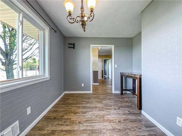 4802 Greenbriar Ln, Everton, AR 72633 - unfurnished dining area featuring a chandelier, wood finished floors, visible vents, and baseboards