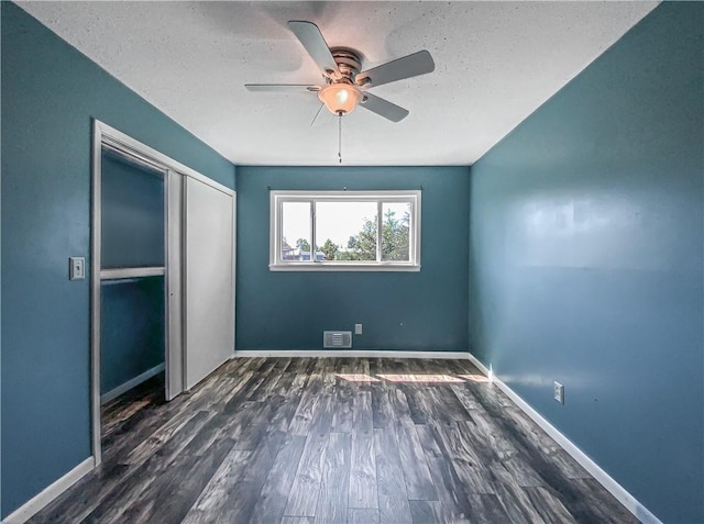 4802 Greenbriar Ln, Everton, AR 72633 - unfurnished bedroom featuring wood finished floors, visible vents, a closet, baseboards, and ceiling fan