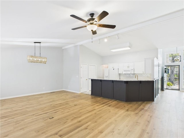 unfurnished living room featuring lofted ceiling, light wood-style flooring, rail lighting, and a ceiling fan