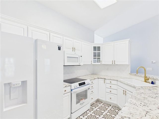 kitchen featuring a sink, vaulted ceiling, white cabinetry, glass insert cabinets, and white appliances