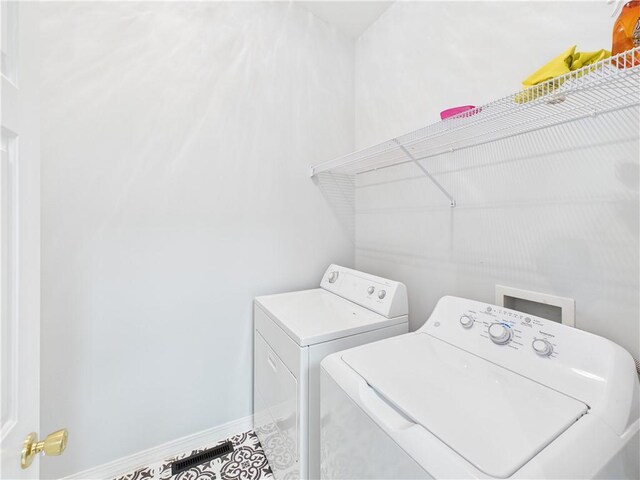 laundry area with washing machine and clothes dryer, baseboards, and laundry area