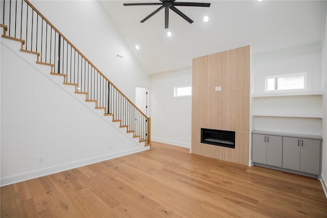 4708 Fieldcrest Ter, Rogers, AR 72758 - unfurnished living room with ceiling fan, stairway, light wood-style floors, ornamental molding, and healthy amount of natural light
