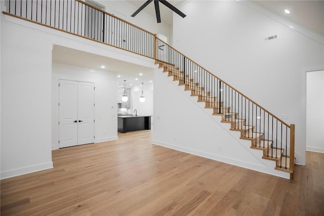 4708 Fieldcrest Ter, Rogers, AR 72758 - stairs with a towering ceiling, a ceiling fan, and wood finished floors