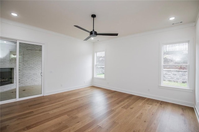 4708 Fieldcrest Ter, Rogers, AR 72758 - spare room with wood finished floors, ceiling fan, ornamental molding, a fireplace, and recessed lighting