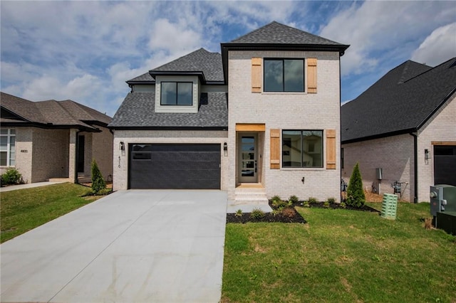 contemporary house featuring brick siding, a shingled roof, a front yard, and concrete driveway