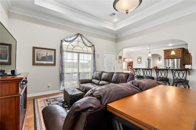 17444 16th Hwy, Siloam Springs, AR 72761 - living area featuring arched walkways, a tray ceiling, light wood-style flooring, baseboards, and crown molding