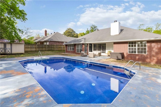 view of swimming pool with fence, an outbuilding, a patio, a fenced in pool, and a storage unit