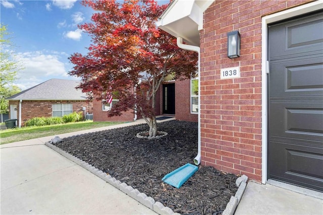 entrance to property featuring brick siding