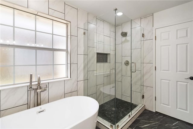 full bathroom featuring a shower stall, marble finish floor, and a soaking tub