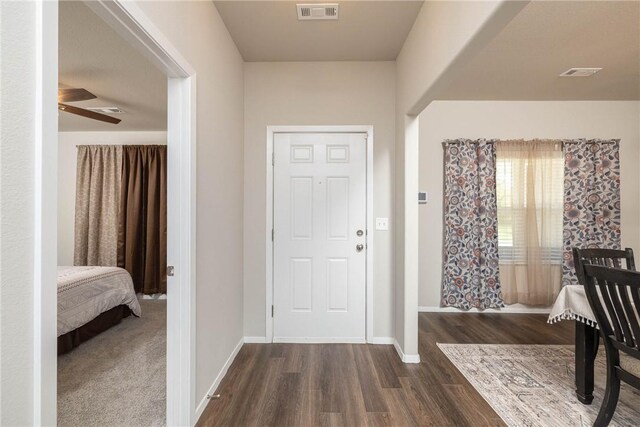 foyer featuring baseboards, a ceiling fan, visible vents, and dark wood-style floors