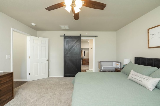 bedroom featuring visible vents, baseboards, carpet floors, and a barn door
