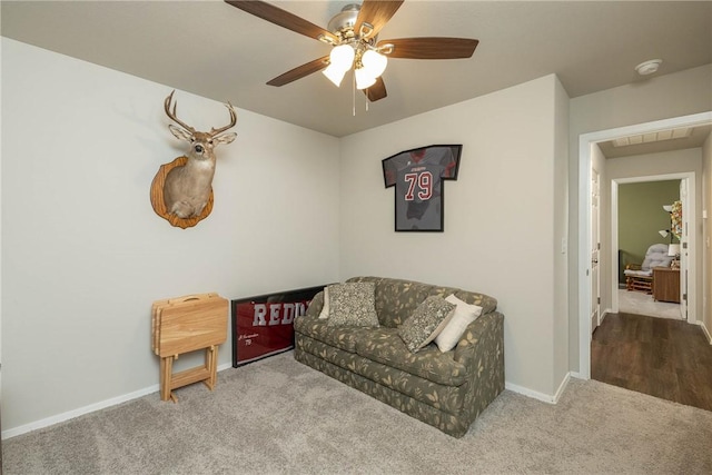 living area with baseboards, carpet, and ceiling fan