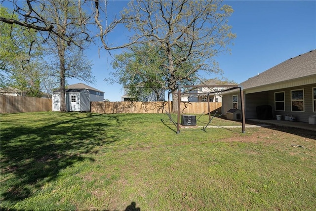 view of yard featuring a fenced backyard, an outbuilding, cooling unit, and a shed