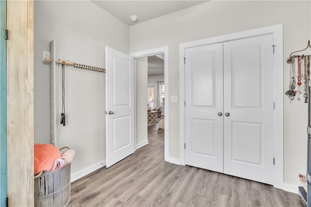 bedroom featuring baseboards, wood finished floors, and a closet
