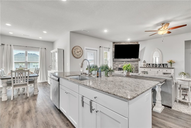 kitchen featuring white cabinets, a sink, wood finished floors, ceiling fan, and dishwasher