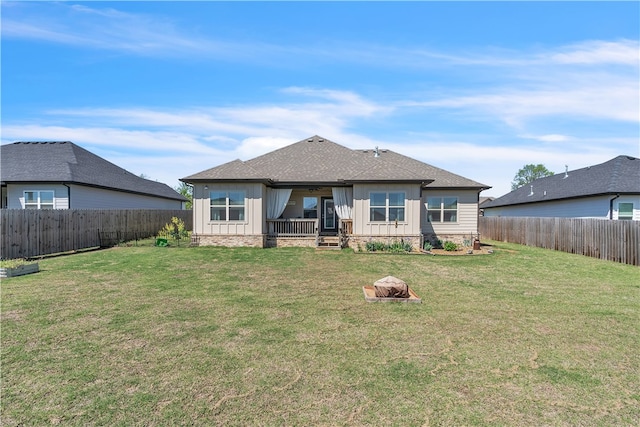back of property featuring board and batten siding, a lawn, and a fenced backyard