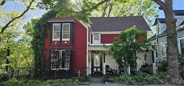 view of front facade with a porch and a fenced front yard
