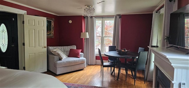 bedroom with crown molding, wood finished floors, and multiple windows