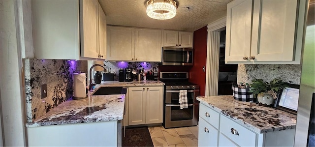 kitchen with marble finish floor, a sink, backsplash, and appliances with stainless steel finishes